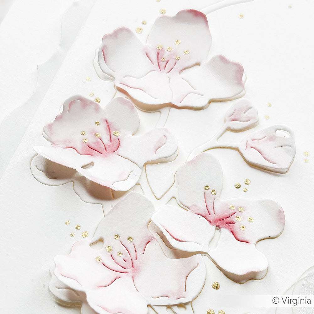 Kirschblüten aus weißem und rosafarbenem Papier mit goldenen Punkten auf weißem Hintergrund, hergestellt mit Alexandra Renke Deep Edge Motivstanzen für präzise, elegante Details.