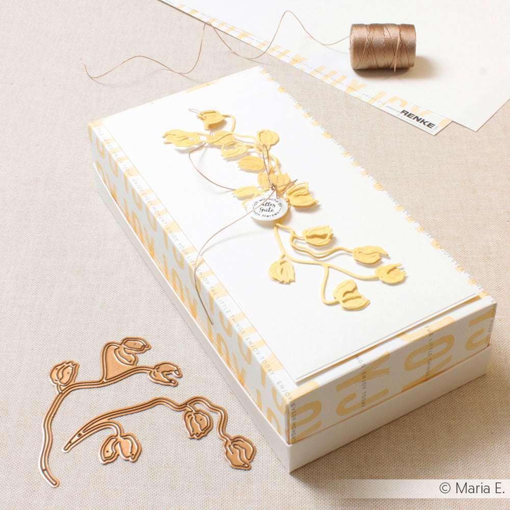 Rechteckige Geschenkschachtel, dekoriert mit gelben Blumen, brauner Schnur und einer passenden Alexandra Renke Deep Edge Motivstanzen-Blumenstanzung auf beigem Stoff.