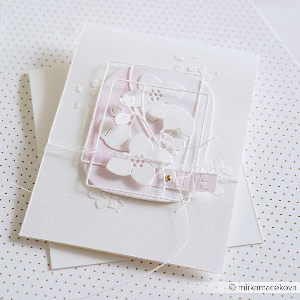 Elegante, weiße Grußkarte mit Blumenprägung von Alexandra Renke, mit einem LOVE-Tag auf gepunktetem Hintergrund mit blassrosa Akzenten und Kordel. Hergestellt mit PAPPcut®ies und Deep Edge Motivstanzen für raffinierte Details.
