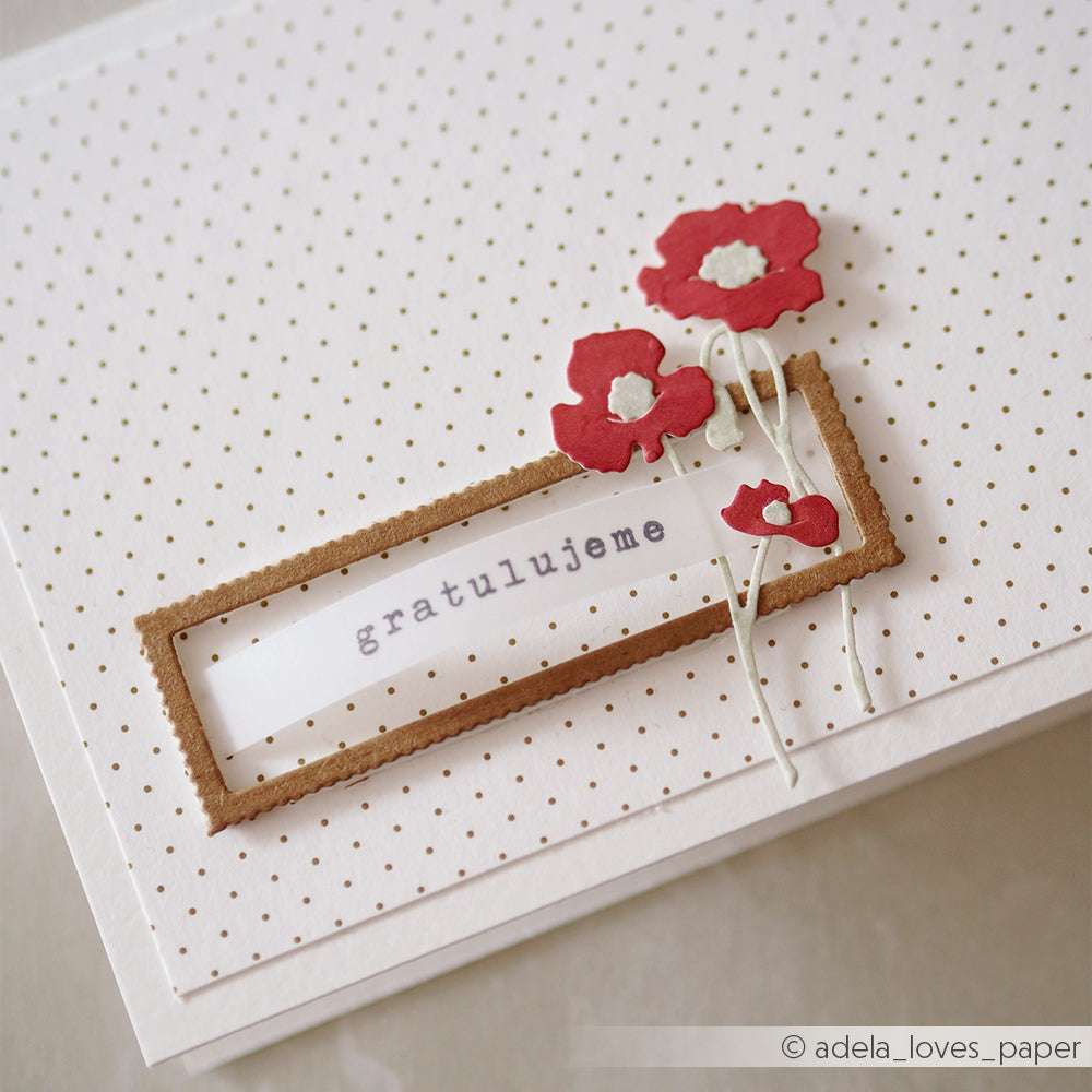 Weiße Karte mit winzigen goldenen Punkten, roten Papierblumen, die mit Alexandra Renke Motivstanze Mini Anemonen hergestellt wurden, und "gratulujeme" in einem braunen rechteckigen Rahmen.