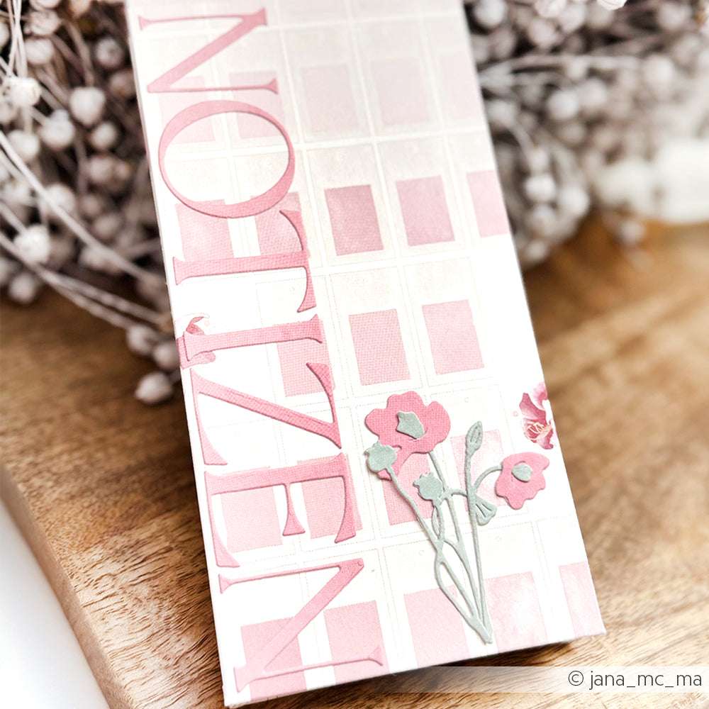 Alexandra Renke Lesezeichen mit rosa "NOTIZEN"-Schriftzug, Gittermuster und rosa Mini-Mohnblumen PAPPcut®ies auf einer Holzunterlage.