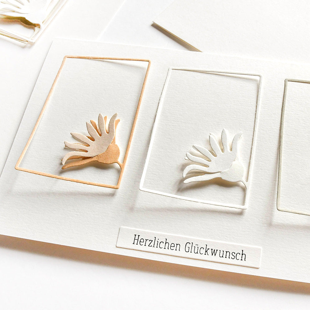Minimalistische Karte von Alexandra Renke mit einer erhabenen abstrakten Blume aus Deep Edge Motivstanzen und dem deutschen Text "Herzlichen Glückwunsch" darunter.