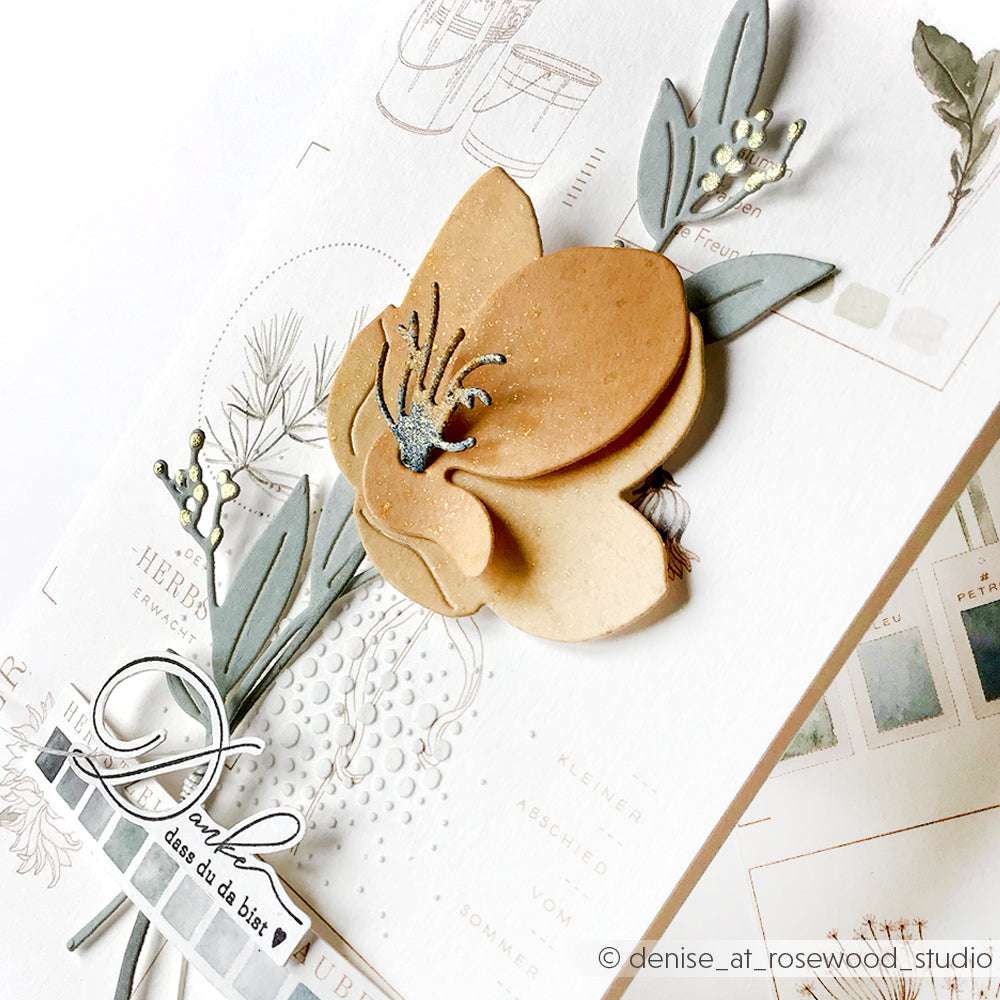 Handgefertigte Karte mit einer geschichteten beigen Blüte, grünen Blättern und zarten gestempelten botanischen Motiven - hergestellt mit Alexandra Renke Deep Edge Motivstanzen für zusätzliche Dimension.