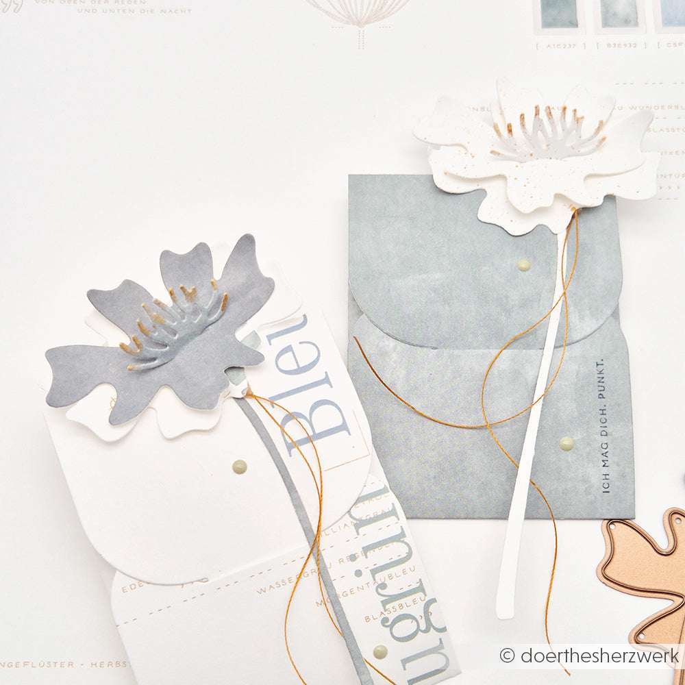 Zwei Blumenkarten mit Papierblumenausschnitten, die mit Alexandra Renke Deep Edge Motivstanzen und goldener Schnur hergestellt wurden. Das Design ist minimalistisch und elegant auf einem hellen Hintergrund.