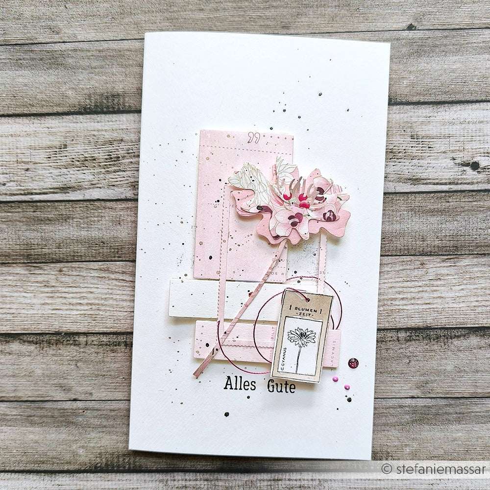 Handgemachte Grußkarte von Alexandra Renke mit rosafarbenem und weißem Lagenpapier, einem floralen Muster aus Deep Edge Stanzen und dem Text "Alles Gute" auf der Vorderseite.