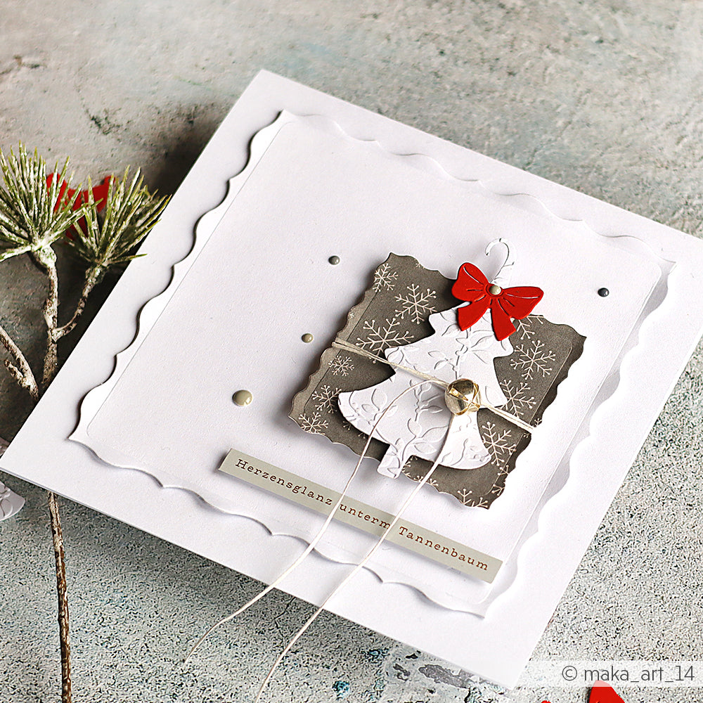 Handgefertigte Weihnachtskarte mit einem Papierbaum aus der Alexandra Renke Motivstanze Fröhliche Tanne, verziert mit einer roten Schleife, einem Glöckchen und festlichen Dekorationen auf hochwertigem Designpapier.
