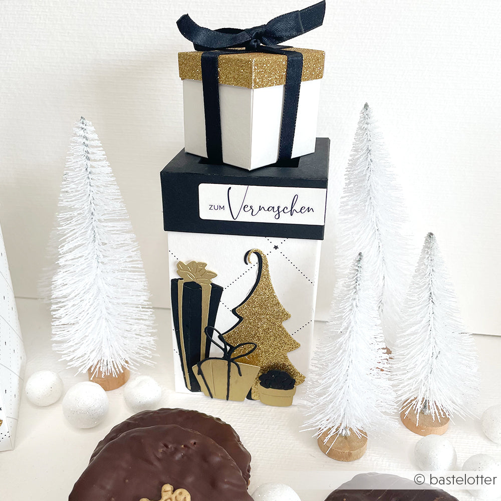 Geschenkschachteln und weiße Tannenbäume mit goldenen Akzenten, umgeben von Plätzchen, weißen Dekokugeln und Alexandra Renke Designpapieren - perfekt für einen festlichen Touch, der mit Präzisionsstanzen oder der Stanze Fröhliche Tanne hergestellt wird.