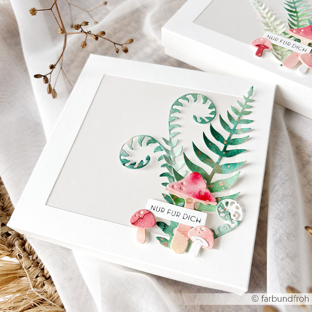 Weiße Schachtel, verziert mit Pilzen und Farnen in Aquarelloptik sowie einem Etikett mit der Aufschrift „NUR FÜR DICH“ auf neutralem Hintergrund – mit zarten „Motivstanze Farnzweige“ als charmante Note, perfekt für Liebhaber einzigartiger Designpapiere und kreativer Stanzsysteme.