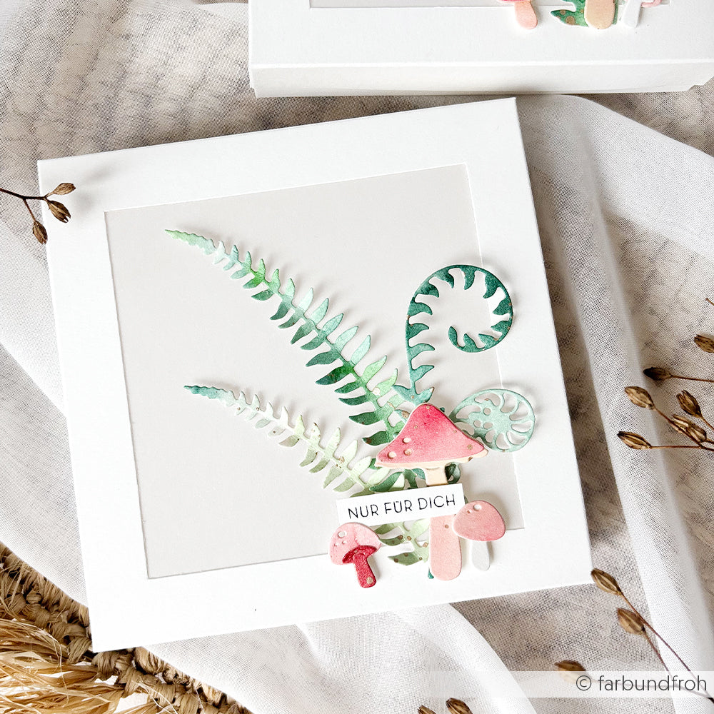 Weiße Karte mit Farn- und Pilzmotiven in Aquarelloptik, gestaltet aus Designpapieren und verziert mit einem zarten Stanzmotiv „Farn-Spiralen“ der Motivstanze, auf deren Vorderseite die Aufschrift „NUR FÜR DICH“ zu sehen ist.