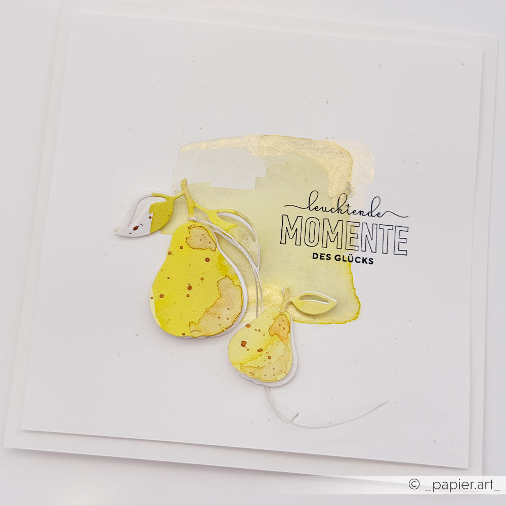Grußkarte mit Birnenmotiven in Aquarelloptik, deutschem Text und einem goldenen Akzent auf weißem, quadratischem Hintergrund – gefertigt aus hochwertigen Designpapieren und verziert mit Birnenmotiven, die mit dem Stanzset „Motivstanze Birnen Duo DieCut Systeme“ ausgestanzt wurden.