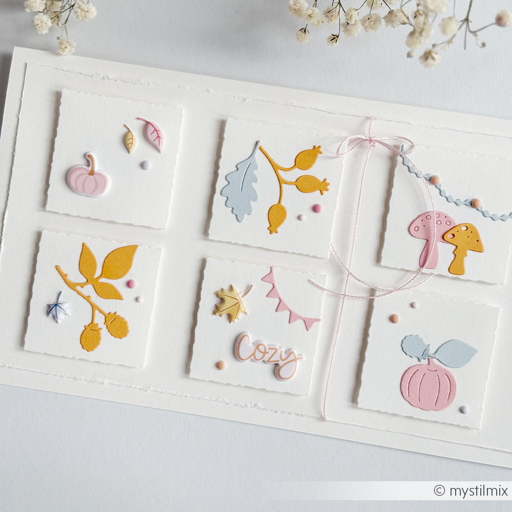 Weiße Grußkarte mit herbstlichen Ausschnitten, die mit Stanzformen wie der „Motivstanze Herbstkonfetti“ gestaltet wurden, pastellfarbenen Verzierungen aus eleganten Designpapieren und einer zartrosa Schleife aus Bindfaden.