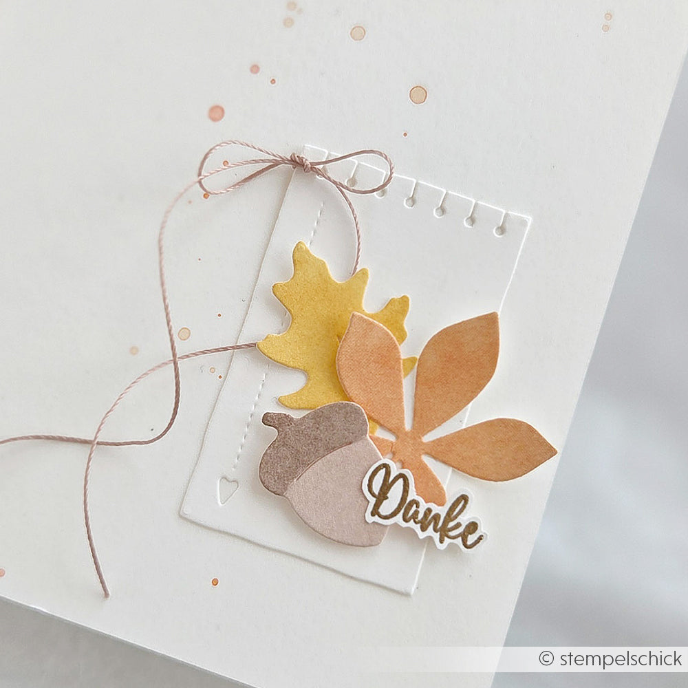 Handgefertigte Karte mit Herbstblättern, gestaltet mit der Motivstanze „Blätterwirbel“, einer Eichel, einer Schleife und dem Wort „Danke“ auf weißem Hintergrund.