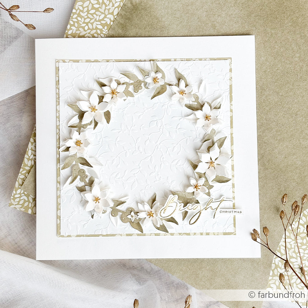 Eine handgefertigte, quadratische Weihnachtskarte mit einem weißen Blumenmotiv „Beerenkranz“ von Motivstanze und dem goldfolierten Schriftzug „Bright Christmas“.