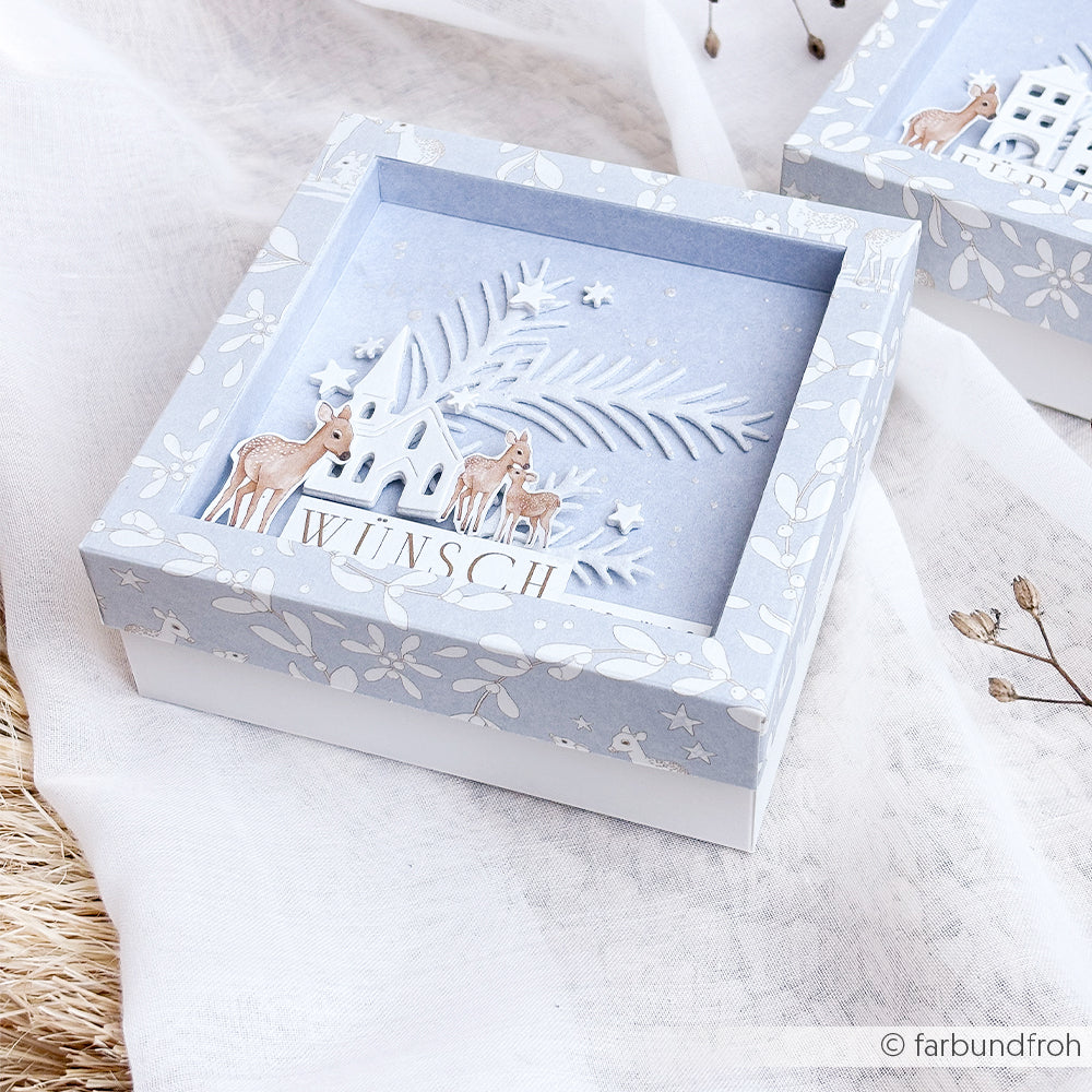 Hellblaue Geschenkbox mit einer Szene mit einem Reh und einem Haus, hergestellt mit deutschen WÜNSCH-Stanzsystemen.