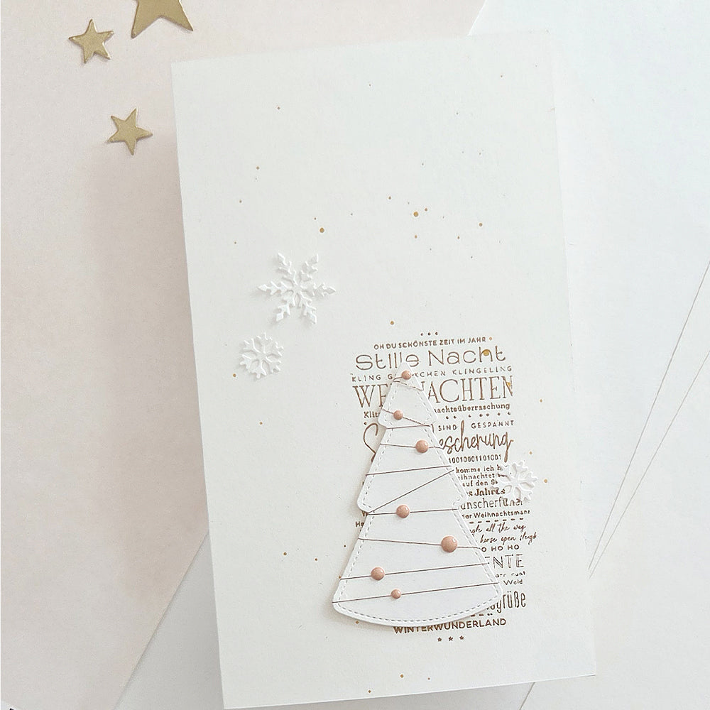 Weihnachtskarte mit einem Motivstanze-Wintertannenbaum, der über einem deutschen Weihnachtstext angeordnet ist.