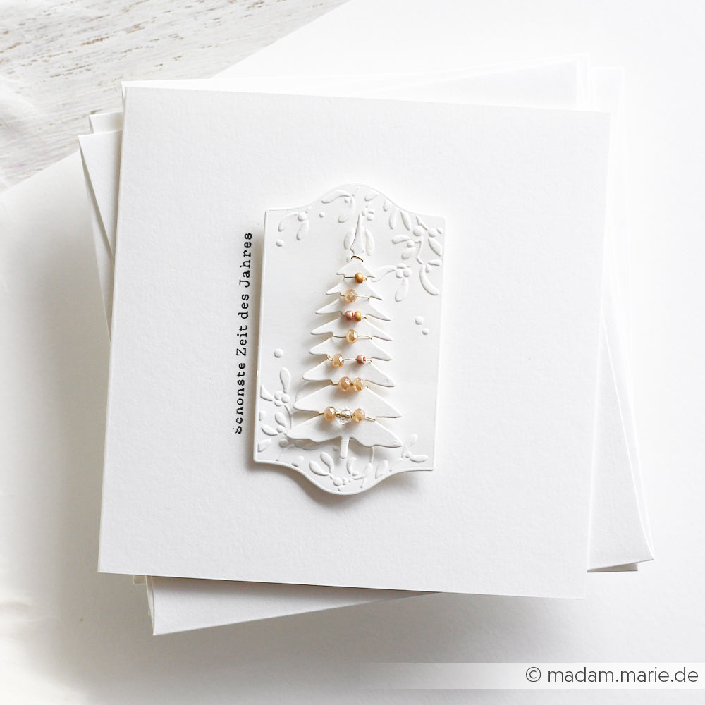 Weiße Weihnachtskarte mit einem 3D-geprägten Kleine Tannen-Motiv, Perlen und dem Schriftzug Schönste Zeit.