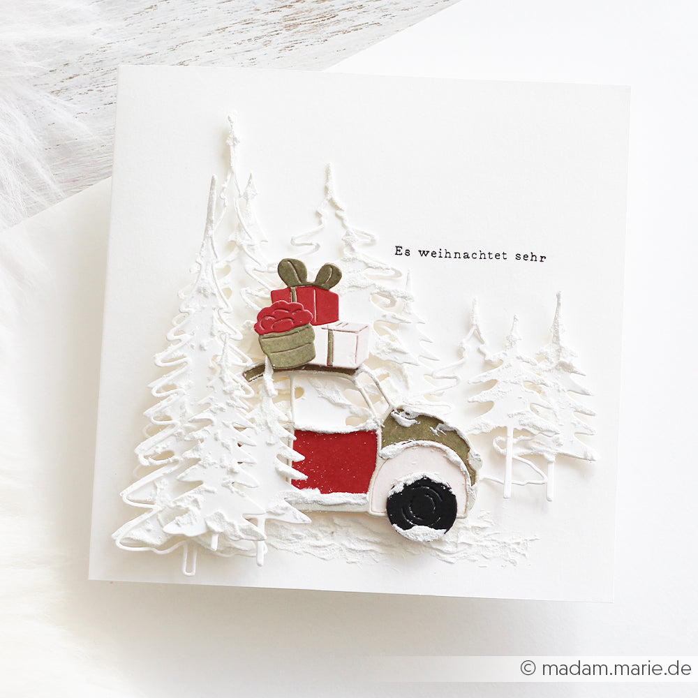 Weihnachtskarte mit zwei Schleifentannen, einem Auto voller Geschenke und dem Schriftzug Es weihnachtet sehr.