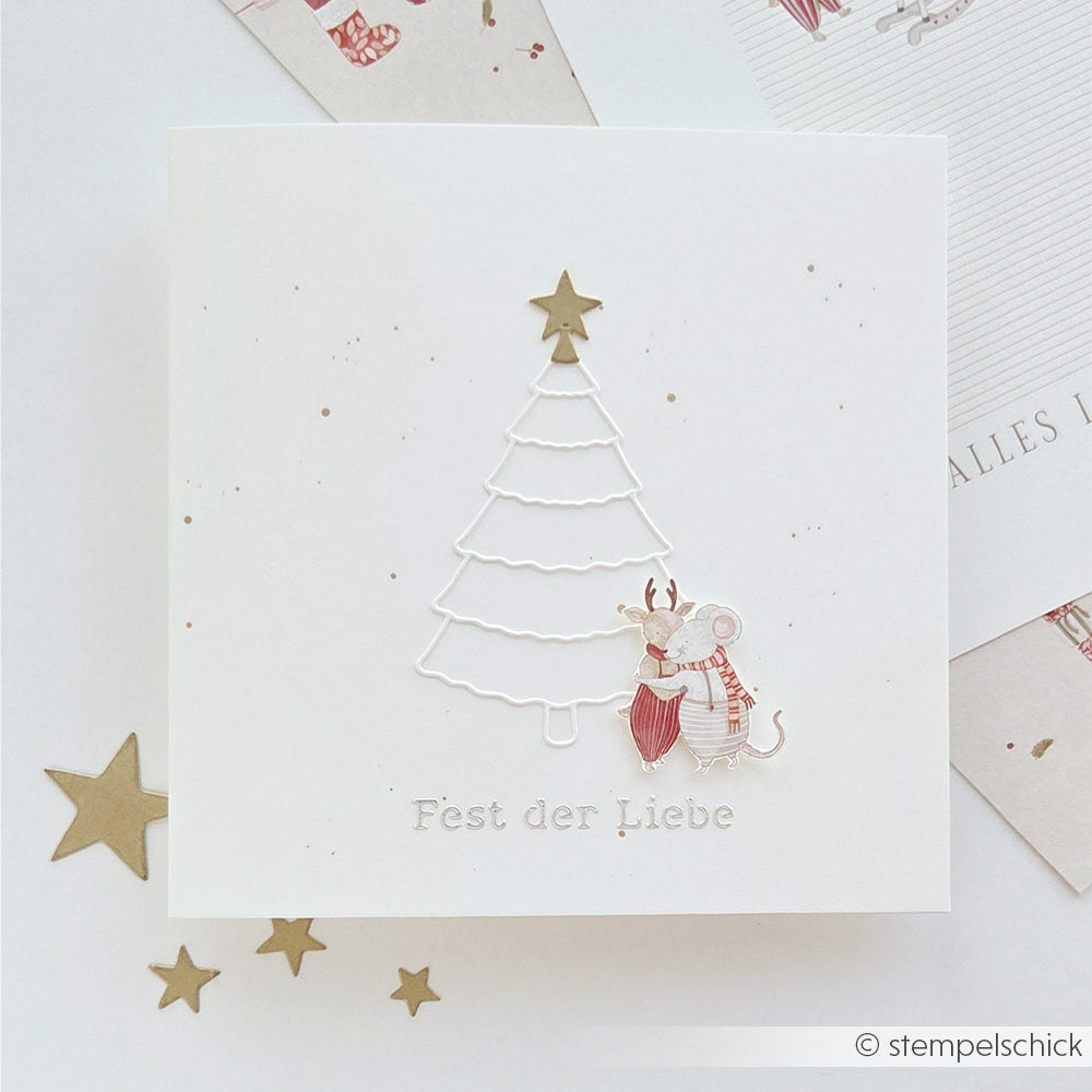 Eine Weihnachtskarte mit einem Baumumriss aus der „Tanne Motivstanze“, zwei sich umarmenden Mäusen und dem deutschen Text „Fest der Liebe“.