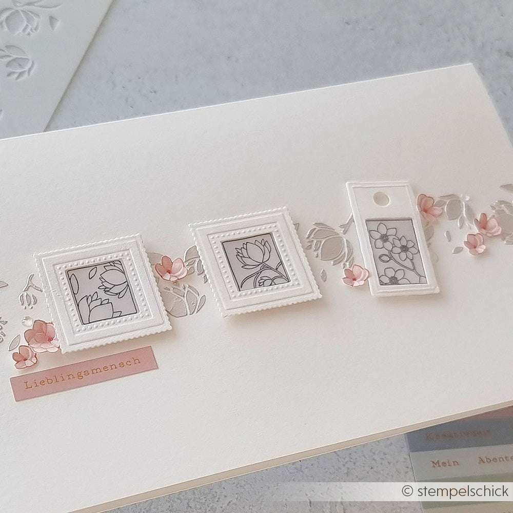 Handgefertigte Karte von Alexandra Renke mit drei eingerahmten Blumenmotiven, einem rosa Blütenornament und der Aufschrift "Lieblingsmensch" auf weißem Hintergrund, gestaltet mit Holzstempel und Stempelkissen.
