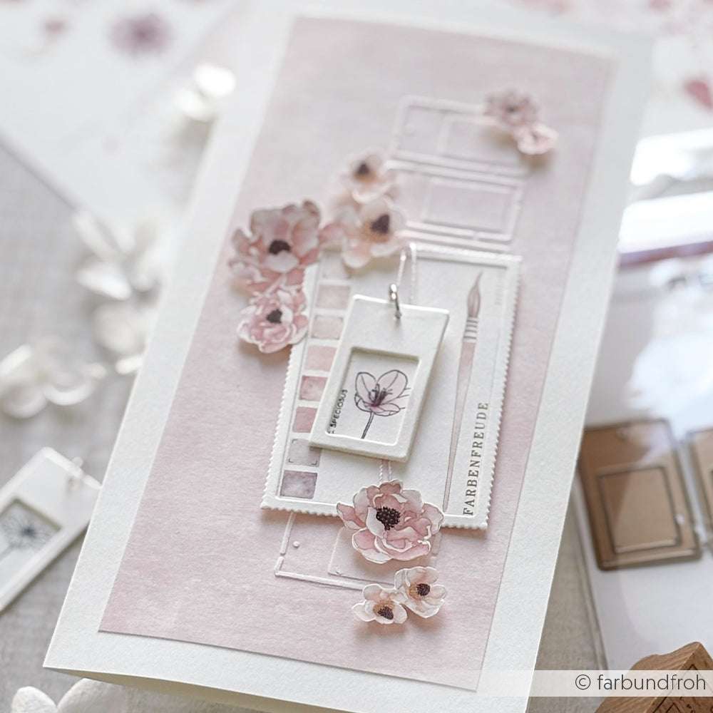 Handgefertigte Karte mit rosafarbenen Blumen, einer kleinen Zeichnung und Malutensilien auf pastellfarbenem Hintergrund mit einzigartigen Motiven aus hochwertigem Holz Holzstempel von Alexandra Renke.