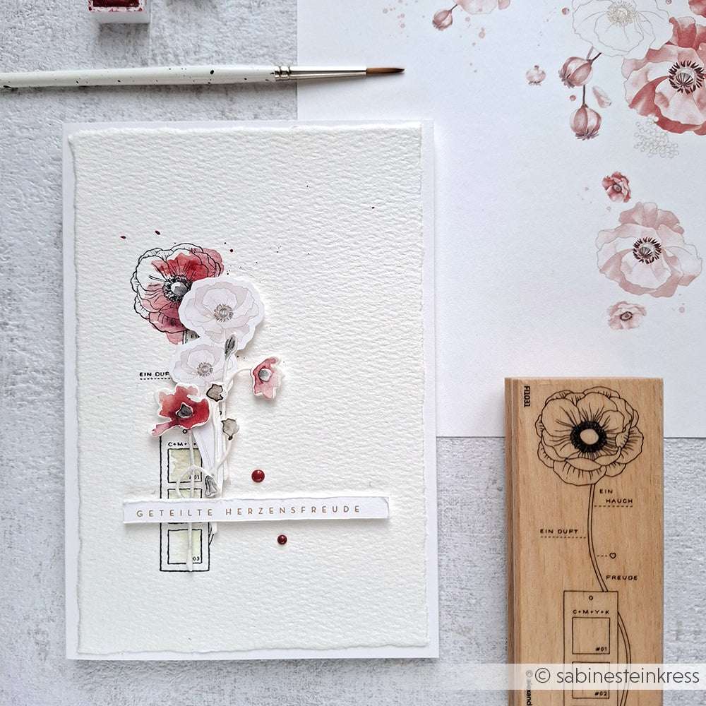 Eine handgefertigte Karte von Alexandra Renke mit aquarellierten Blumen, einem Stempelgummi-Blumenstempel und dem Text GETEILTE HERZENSFREUDE - perfekt für kreative Papierprojekte.