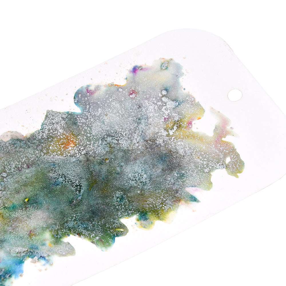 Abstrakte Aquarell- und Glitzerfarben auf einem weißen Anhänger mit Loch oben rechts, mit einzigartiger Farbgebung, erstellt mit Lindy's Stamp Gang's hochpigmentiertem Pulver.