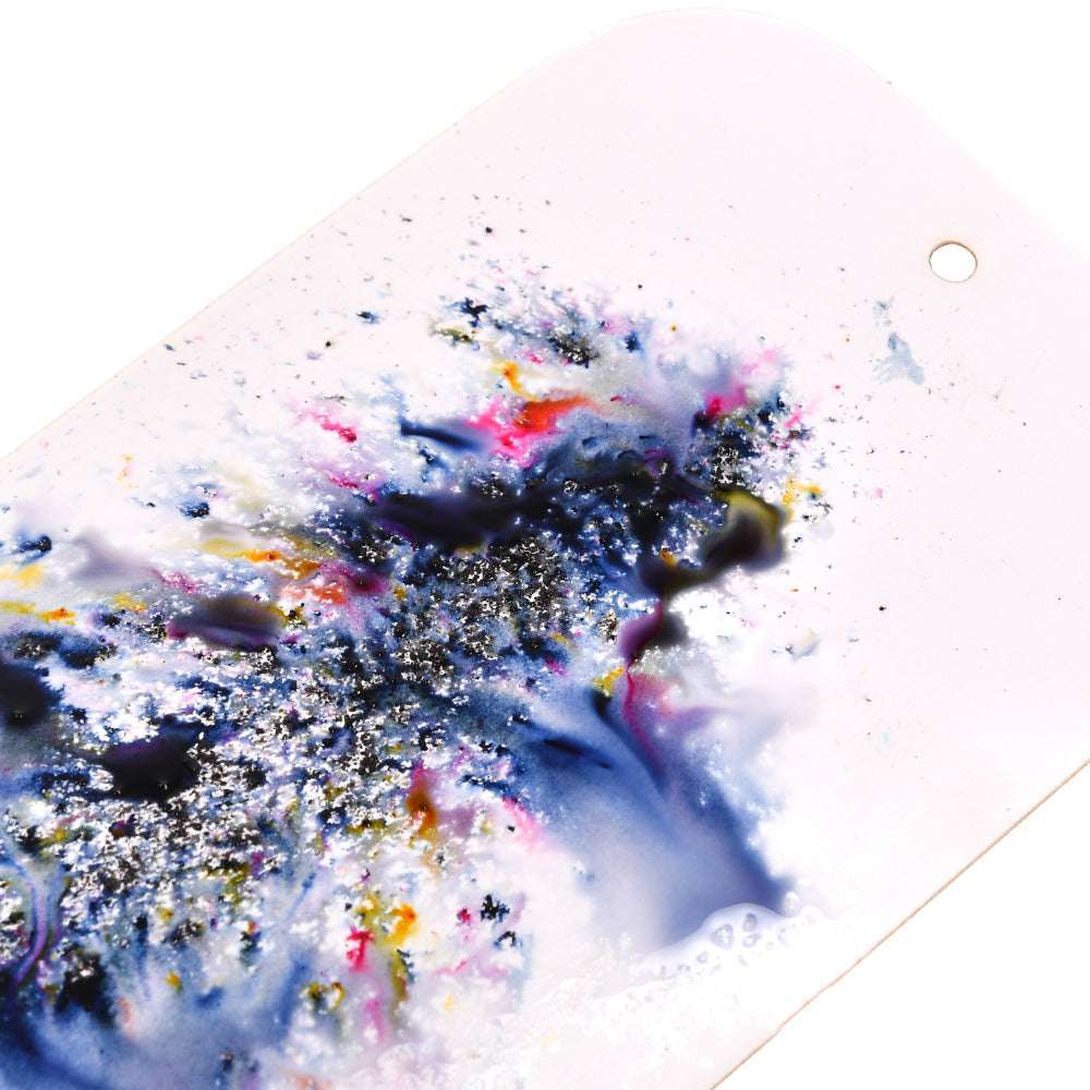 Nahaufnahme eines lebendigen, abstrakten Farbmusters mit silbernem Glitter und matten Effekten auf einer weißen, rechteckigen Oberfläche, die durch das hochpigmentierte Pulver von Lindy's Stamp Gang ein atemberaubendes Finish erhält.