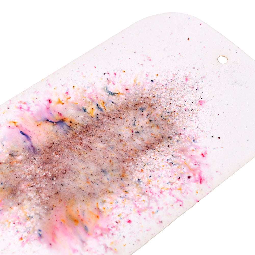 Lindy's Stamp Gang weiße, rechteckige Keramikfliese mit matter Oberfläche, die in der Mitte einen bunten, hochpigmentierten Pulverspritzer und an einem Ende ein Loch aufweist.