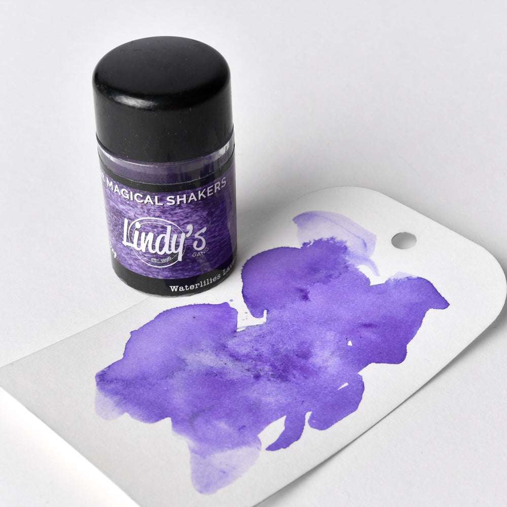 Ein Lindy's Stamp Gang Magical Shaker Döschen mit hochpigmentiertem Puder und einem Anhänger mit einem lila Aquarellmuster.