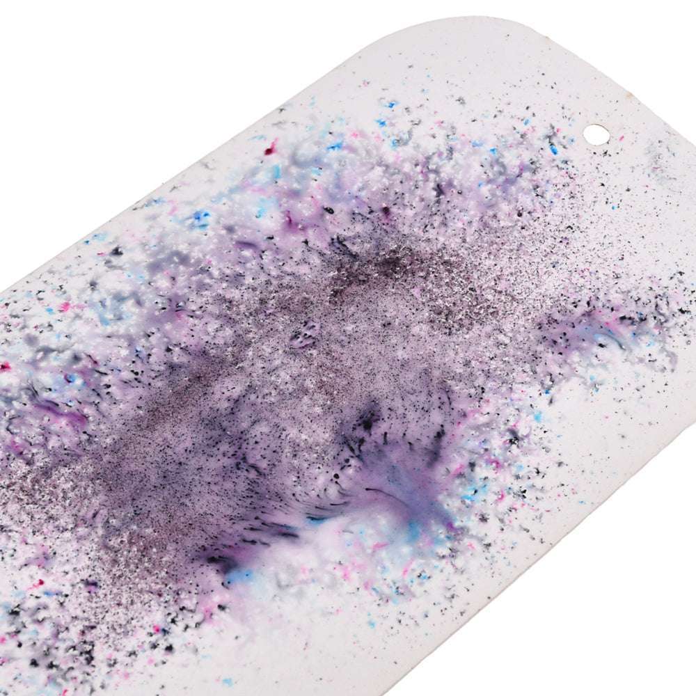 Lindy's Stamp Gang Skateboard-Deck in Weiß mit mattem Finish, mit lila, blauen und schwarzen Splatter-Effekten und einem kleinen Loch in der Nähe des Randes.