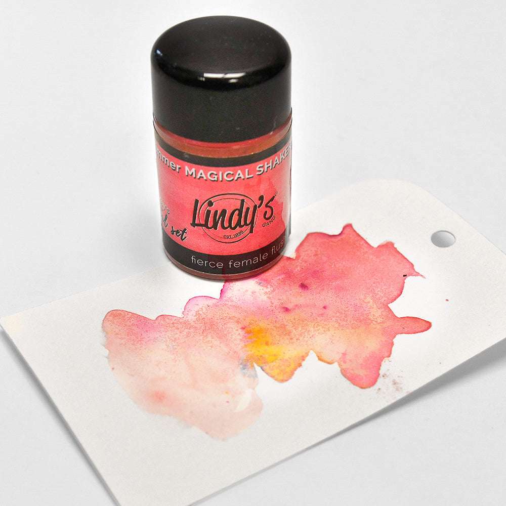 Eine Dose Lindy's Stamp Gang Magical Shaker mit hochpigmentiertem Pulver und einem Etikett mit einem rosa Aquarellspritzer auf weißem Hintergrund.