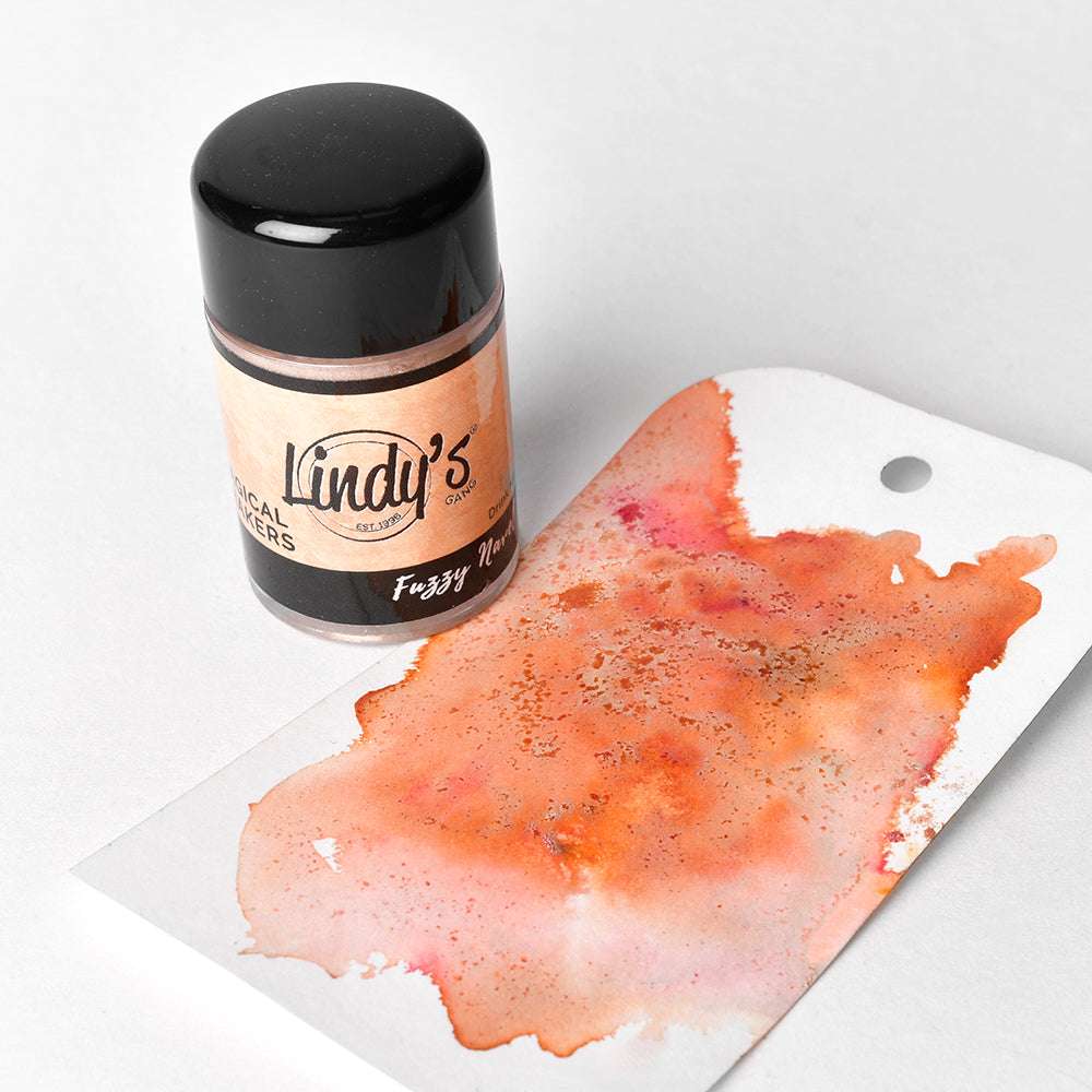 Eine Dose Lindy's Stamp Gang-Pulver steht neben einem mit orangefarbener und goldener Aquarellfarbe geschmückten Anhänger, der eine einzigartige Farbgebung zeigt.