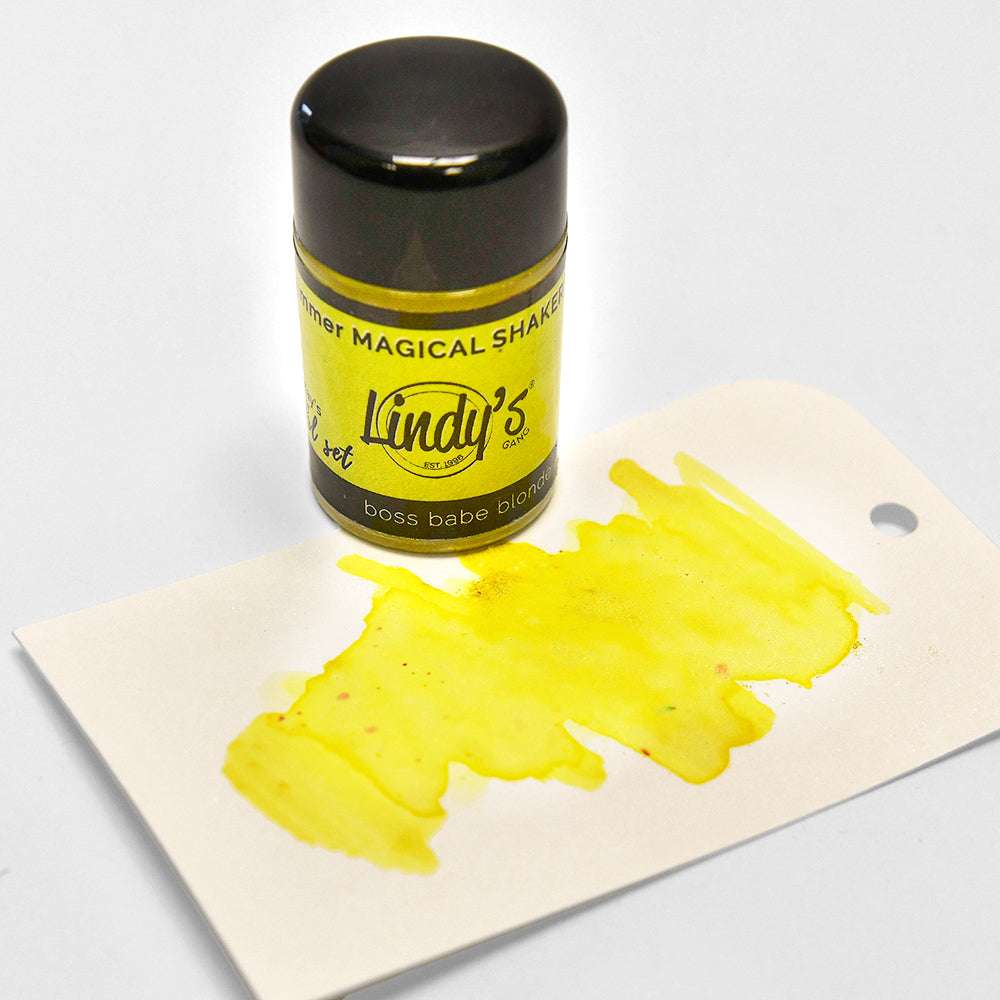 Ein gelber Lindy's Stamp Gang Magical Shaker mit hochpigmentiertem Pulver und einem weißen Anhänger mit einem leuchtend gelben Aquarellmuster.