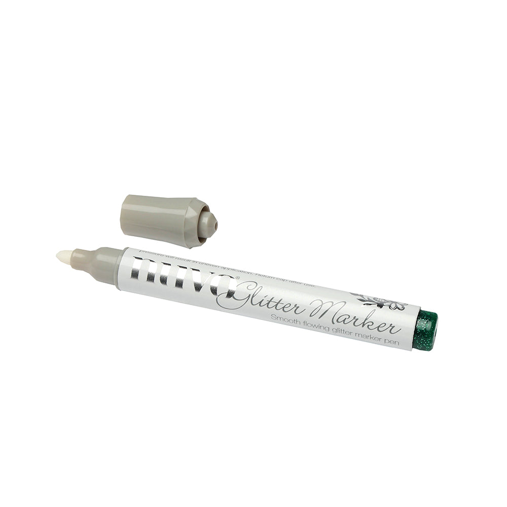 Ein silberner und weißer Glittermarker von Tonic Studios, dessen graue Kappe entfernt und daneben gelegt wurde. Perfekt, um Ihren Bastelprojekten einen funkelnden Touch zu verleihen.