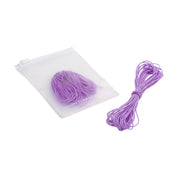 Neben einem durchscheinenden Beutel, der mit weiteren violetten Kordeln gefüllt ist, liegt ein Bündel violetter, elastischer Makramee-Kordeln von Alexandra Renke.