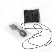 Eine Spule schwarzes Elastikband von Alexandra Renke liegt neben einem wiederverschließbaren Beutel mit zusätzlicher Kordel, ideal für das Bastelprojekt, alles auf weißem Hintergrund.