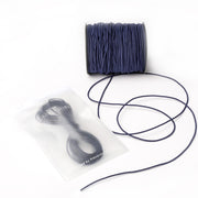 Eine Spule marineblaues Elastikband von Alexandra Renke mit abgewickelter Kordel und zusätzlicher Kordel in einem versiegelten Beutel - ideal für Ihr nächstes Bastelprojekt.