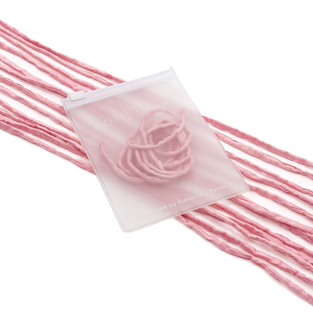 Durchsichtiger Beutel von ☆ mit einem rosa Garnmuster auf mehreren rosa Garnsträngen vor weißem Hintergrund, verziert mit exquisiten handgenähten Details – perfekt für elegante Geschenkverpackungen.
