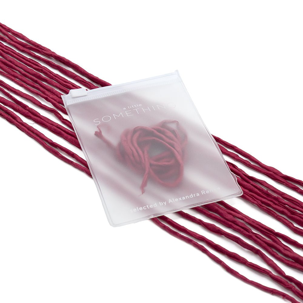 Ein durchscheinender, ☆ handgenähter Beutel mit rotem Garn im Inneren, der neben mehreren Strängen passender Seidenschnur liegt, eignet sich hervorragend für elegante Geschenkverpackungen.