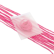 Ein ☆ durchsichtiger Beutel, handgenäht für den besonderen Charme und mit rosa Garn gefüllt, ist auf mehreren Strängen rosa Garn ausgestellt.