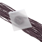 Ein mattierter Plastikbeutel von ☆ mit der Aufschrift „A Little Something“ hängt an violetten Seidenschnur-Bändern und eignet sich somit hervorragend als Geschenkverpackung.