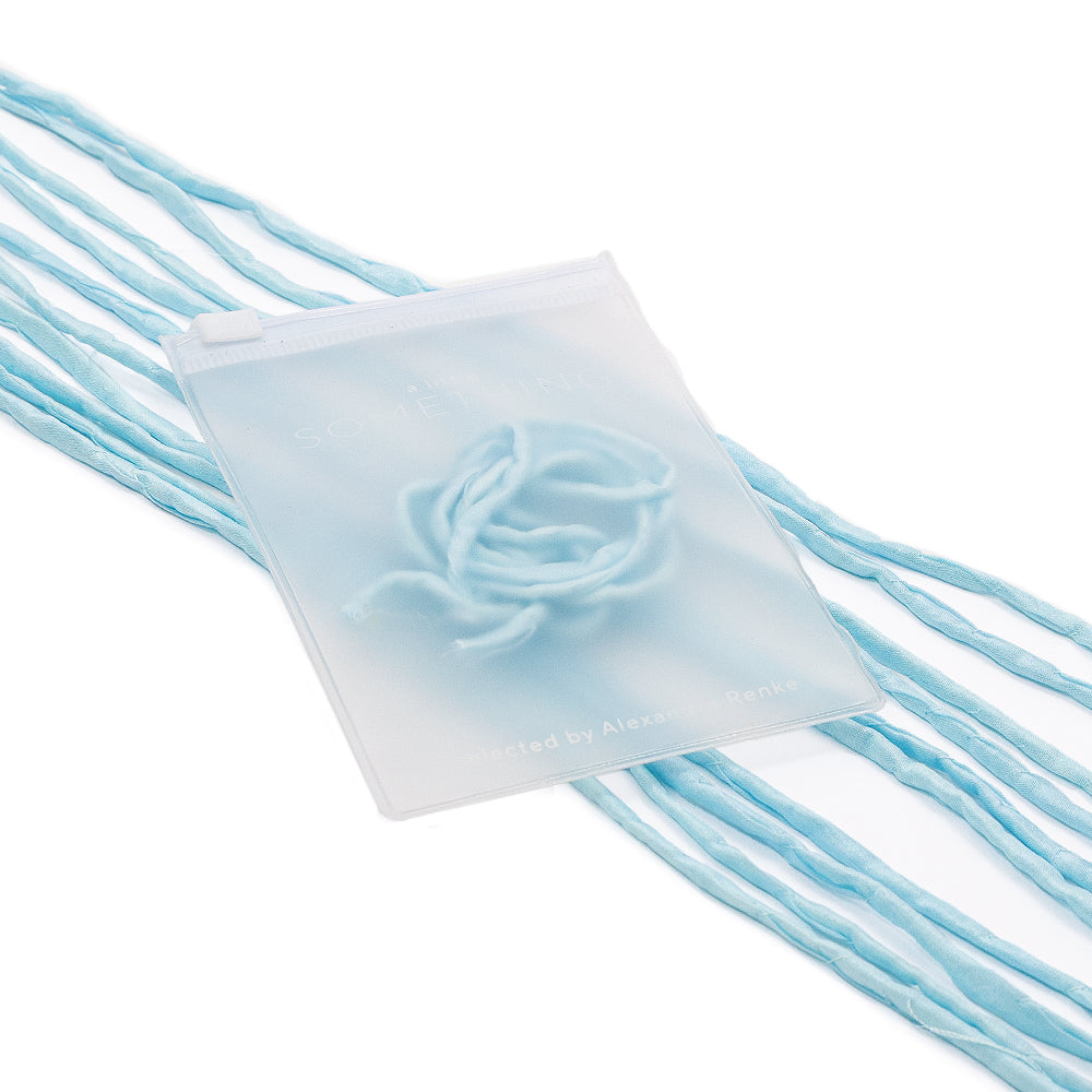 Ein mattierter Beutel von ☆ mit einer blauen Rose im Inneren, verziert mit mehreren blauen Seidenschnur-Fäden, verleiht eleganten Geschenkverpackungen den perfekten letzten Schliff.