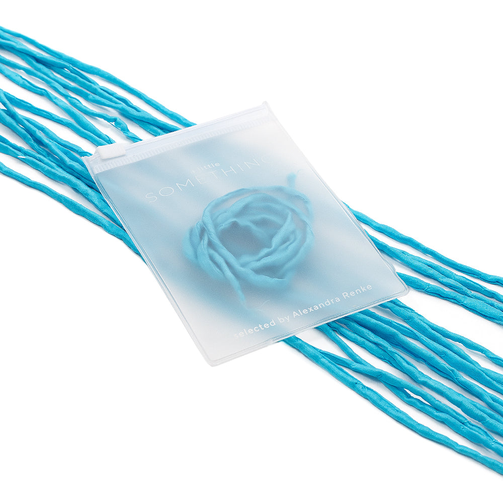 Ein durchscheinender Beutel von ☆, aus dem an beiden Seiten blaue Seidenschnur-Fäden herausragen, die elegant auf dem weißen Untergrund angeordnet sind – perfekt für exquisite Geschenkverpackungen und liebevoll handgenäht für eine einzigartige Note.