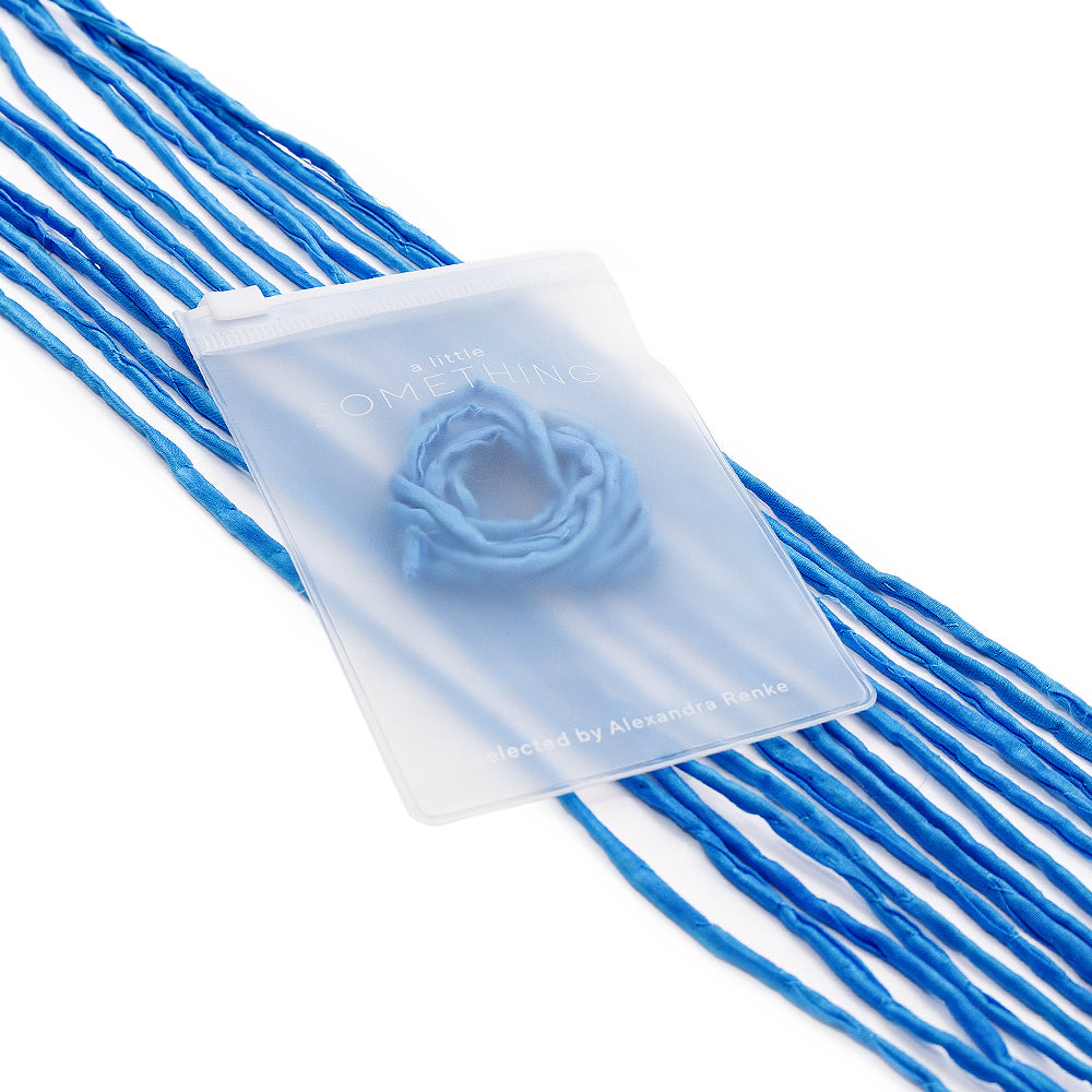 Ein durchscheinender Beutel, der an einer blauen Seidenschnur befestigt ist und mit einem Schriftzug versehen ist, umschließt ein rosaförmiges blaues Objekt von ☆ – eine ideale Wahl für handgenähte Geschenkverpackungen.