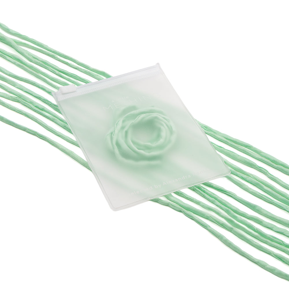 Durchsichtiger Beutel mit erhabenem Rosenmotiv, handgenäht und an einer langen, grünen Seidenschnur von ☆ aufgehängt – perfekt für elegante Geschenkverpackungen.