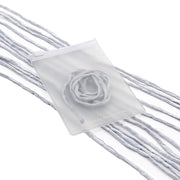 Ein durchscheinender Beutel von ☆, in dem sich ein aufgerollter hellblauer Schal befindet, verziert mit losen Stofffäden aus passendem Material und elegant mit einer Seidenschnur veredelt – ideal für außergewöhnliche Geschenkverpackungen oder als zartes, handgenähtes Accessoire.