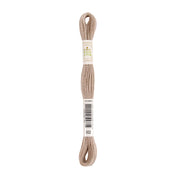 Ein Strang beiges Stickgarn mit Etiketten, auf denen „DMC ECO VITA“ und die Artikelnummer 002 angegeben sind – natürlich gefärbtes Garn für Ihre umweltfreundlichen Stickprojekte.