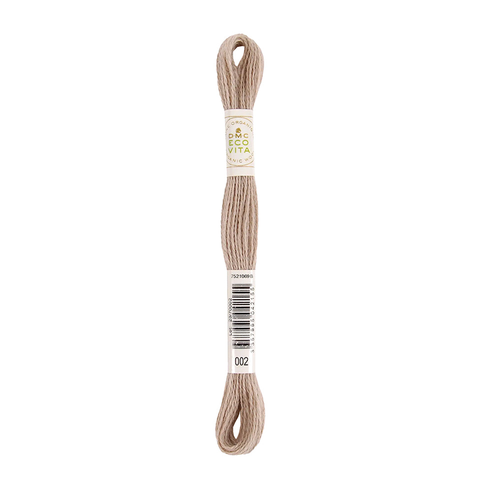Ein Strang beiges Stickgarn mit Etiketten, auf denen „DMC ECO VITA“ und die Artikelnummer 002 angegeben sind – natürlich gefärbtes Garn für Ihre umweltfreundlichen Stickprojekte.
