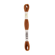 Ein Strang braunes Stickgarn mit einem weißen Etikett und einem Barcode in der Mitte, hergestellt aus natürlich gefärbtem Garn für Ihre Stickprojekte.