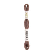 Ein Knäuel braunes Stickgarn der Marke „Ecco Vita“ mit einem Barcode und der Nummer 104. Dieses Stickgarn besteht aus natürlich gefärbtem Garn und eignet sich perfekt, um Ihren Stickprojekten eine umweltfreundliche Note zu verleihen.